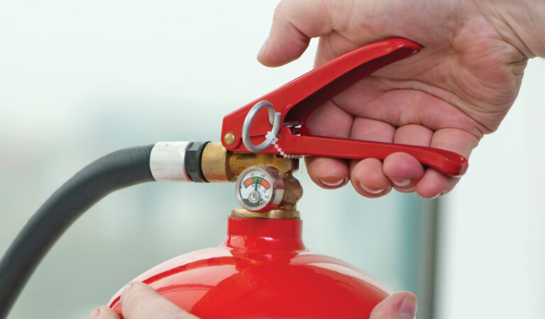 A person demonstrating how to use a fire extinguisher.