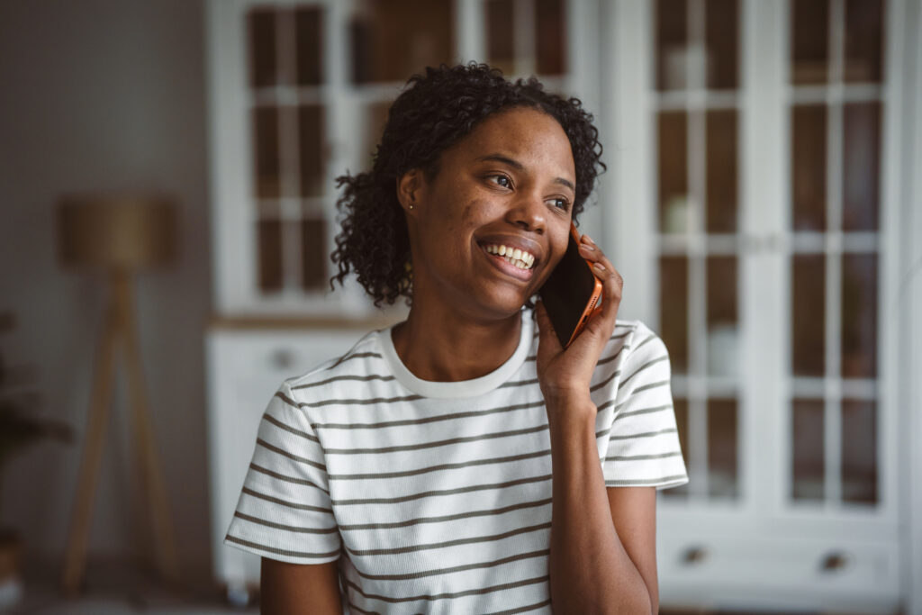 Policyholder speaking on the phone with a housing coordinator about human connection in temporary housing